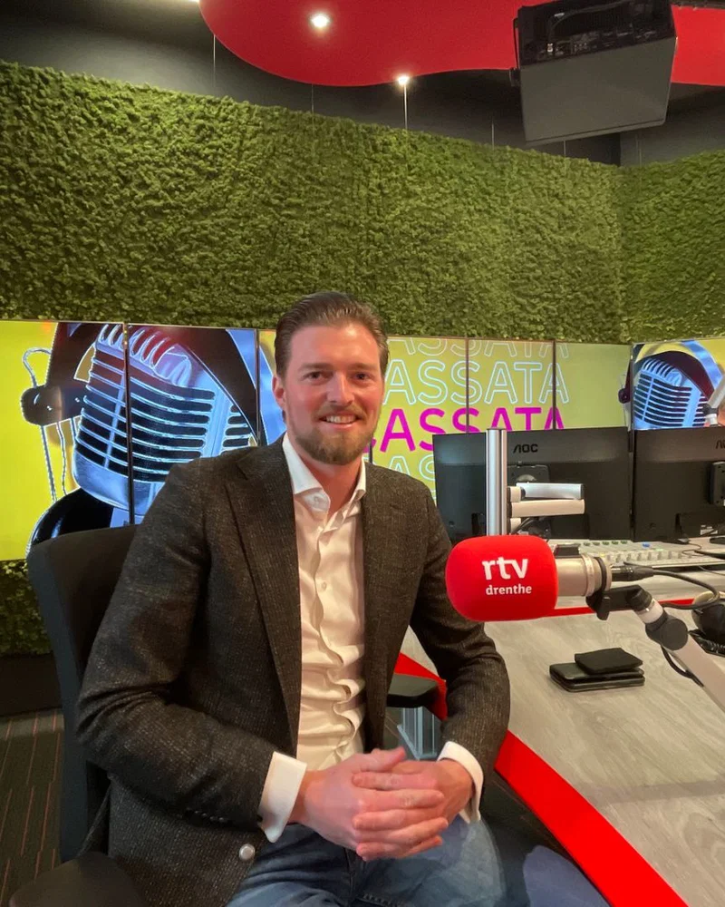 Erjen in colbert achter een bureau, netjes, keurig, denkend aan vrijdagavond